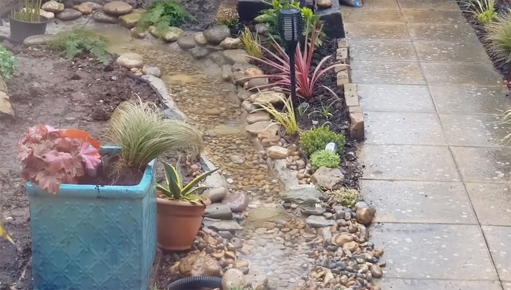 Garden stream water feature with rocks and pebbles
